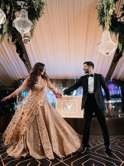 A classic pose from a couple's first dance at their reception. The elegant decor with hanging chandeliers provides a sophisticated backdrop for their romantic routine.