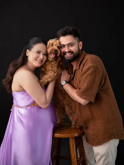 The whole family, including the furry member. This portrait shows the couple with their beloved dog, all smiling for the camera. It’s a perfect representation of their complete family unit.