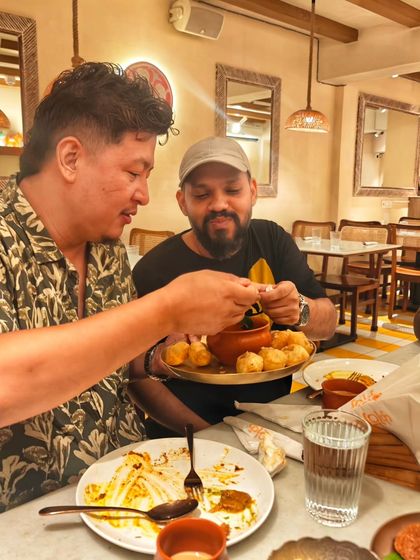 Two guests sharing and enjoying a plate of snacks at our home chef meet-up. These events are all about community, networking, and of course, eating a lot of mouthwatering food.