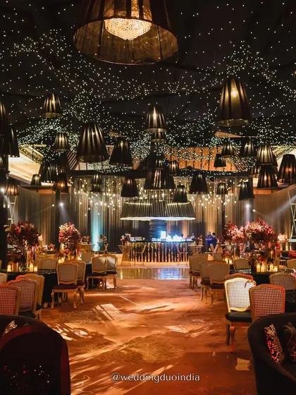 We believe in making weddings cinematic. For this Udaipur sangeet, we designed a starry night ceiling with hundreds of fairy lights and dramatic black lampshades, creating a moody, romantic, and utterly unforgettable ambiance for a night of celebration.