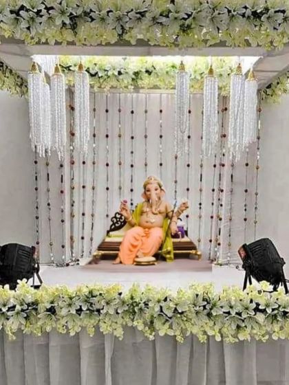 An elegant white floral mandap with hanging crystal chandeliers. This design is perfect for those who want a sophisticated and glamorous look for their festive celebration.