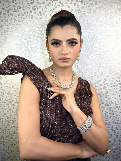 A portrait of this stunning party look. The high bun and dramatic makeup create a look that is both modern and timeless.