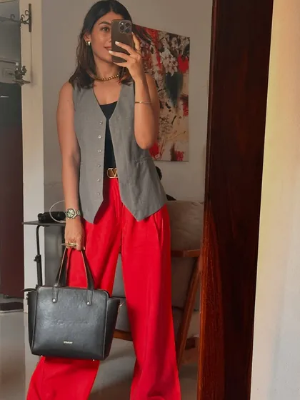 Another example of styling, not labeling. This look, featuring a grey vest and bold red trousers, shows how you can mix formal and trendy pieces to create a unique and powerful outfit for any occasion.