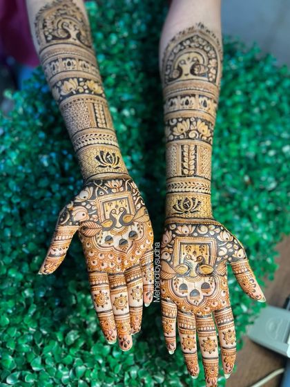 The same peacock and lotus engagement design against a leafy green background.