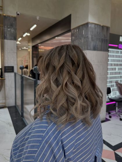 A perfect ash blonde color for the holiday season. The cool tones and soft curls create a festive and elegant look.