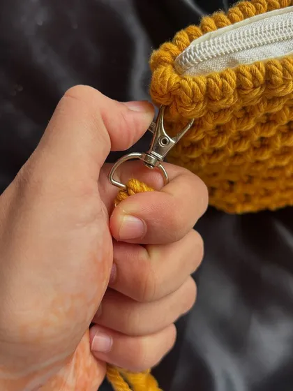 We use high-quality hardware on our bags, like this sturdy metal clasp for the detachable strap. It ensures your bag is secure and long-lasting.