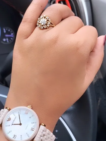A detail shot of the accessories for a lunch date. A classic watch and a statement ring add a touch of sophistication and personal style.