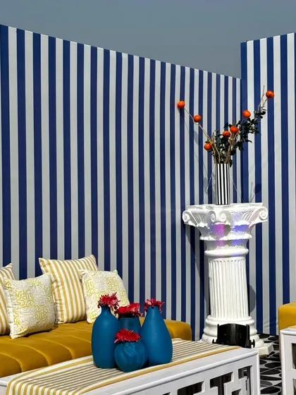 A full view of the chic lounge seating we designed. The combination of the striped wall, geometric coffee table, and mustard yellow sofa creates a sophisticated and modern coastal vibe for the festival.
