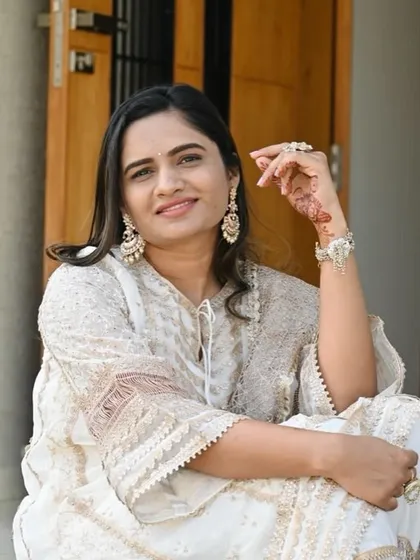 A client showing the versatility of our jewelry. Here, she styles our pearl chandbali earrings with a beautiful white chikankari suit for an elegant and timeless look.