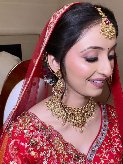 A happy, smiling bride. The soft pink tones in her makeup give her a youthful and fresh glow, perfect for her wedding day.