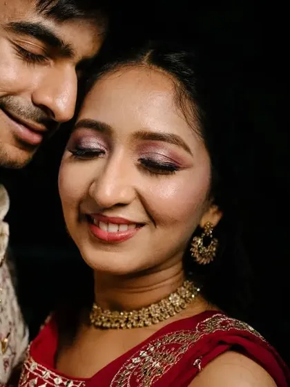 A close-up portrait filled with emotion and tenderness. This shot focuses on their peaceful expressions and the beautiful details of her makeup and his traditional attire.