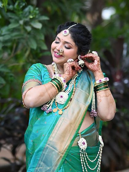 Getting ready for the ceremony. This candid shot shows the intricate details of the floral jewelry and the soft, elegant makeup.