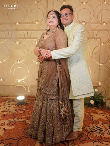 Why buy when you can rent the best? This couple is ready for a reception in a brown sequined lehenga and a mint green sherwani.