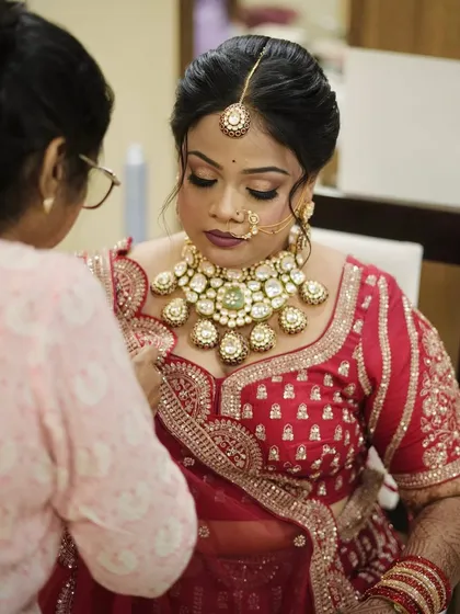 Final touches on the bride. Here, I am placing the stunning kundan and emerald choker from my personal jewellery collection.