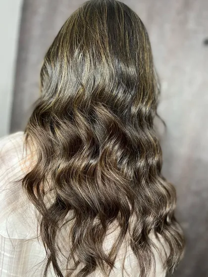 The beautiful result of the ash blonde highlights, styled in loose waves.