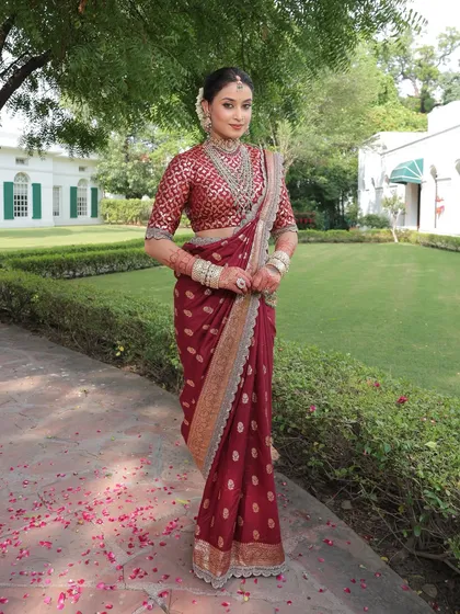 An example of timeless elegance. This bride's look is built around a beautiful maroon saree, enhanced with soft, natural makeup and a traditional hair bun, perfect for a classic wedding ceremony.