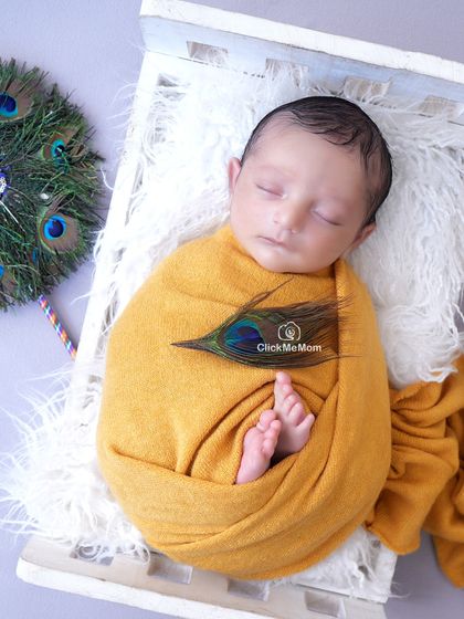Celebrating little Krishna with all the traditional elements. Here, our baby Kanha is swaddled in auspicious yellow, with a peacock feather and his tiny feet peeking out.