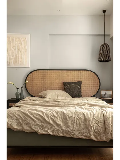 This guest bedroom is defined by its calm and soothing atmosphere. The textured rattan headboard adds a touch of old-world charm, while the soft beige tones and minimalist decor create a peaceful retreat for visitors.