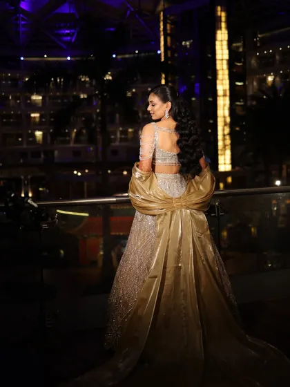This photo captures the drama and elegance of the bride's Sangeet look against the beautiful backdrop of the hotel at night.