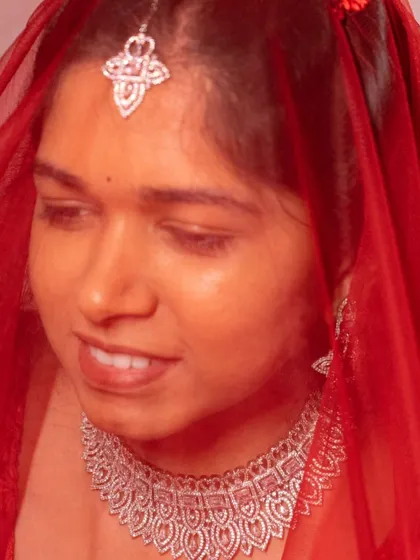 A beautiful, soft-focus shot of our client wearing the AD choker and maang tikka. The red veil adds a touch of bridal drama to this modern jewellery set.