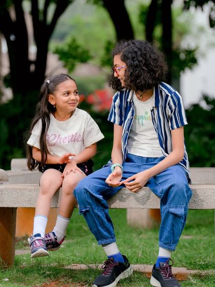 Capturing the special connection between sisters. This candid shot shows a moment of shared conversation and friendship during their outdoor portrait session.