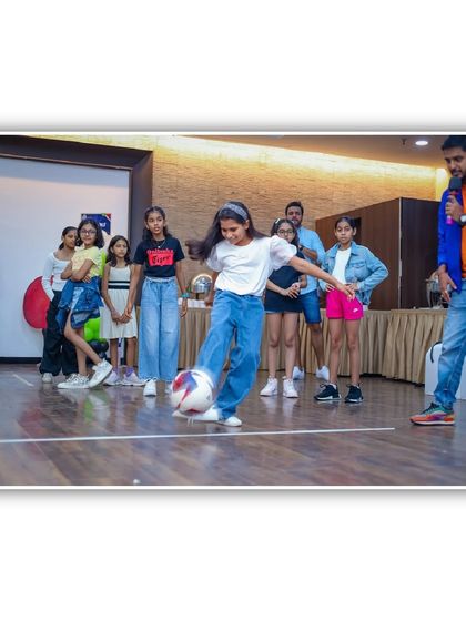 A young football fan shows off her skills in a soccer challenge game, guided by our event anchor. It's a great way to incorporate sports into the party fun.
