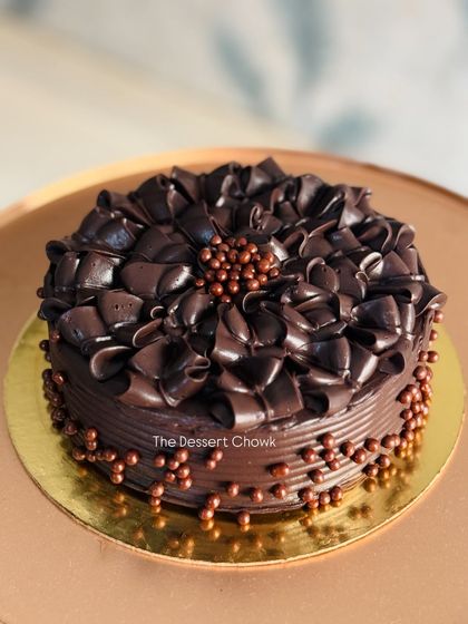 An intensely chocolatey cake decorated with rich chocolate shavings and crispy chocolate pearls.