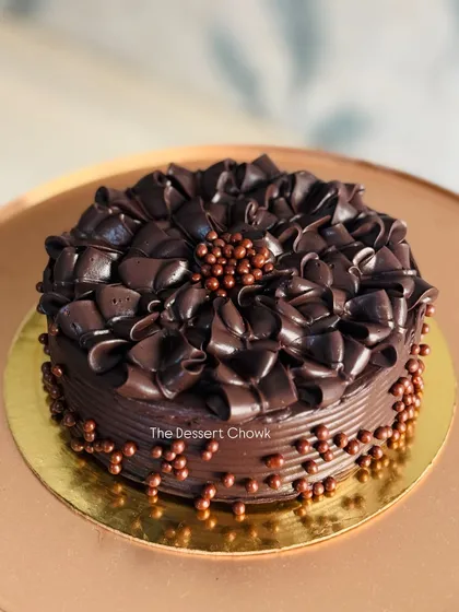 An intensely chocolatey cake decorated with rich chocolate shavings and crispy chocolate pearls.