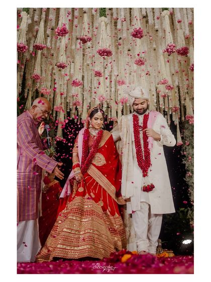 A full view of the couple on stage during their Pheras, surrounded by stunning floral decor.