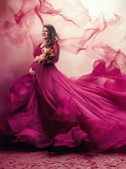 To create a sense of movement and drama, I use techniques like fabric tossing. This captures the magenta gown in full flight, surrounding the mother-to-be in a cloud of color and energy.