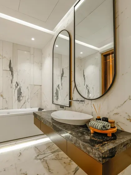 A different view of the guest bathroom, showing the full-height white marble wall with dramatic grey veining, which contrasts beautifully with the dark countertop.