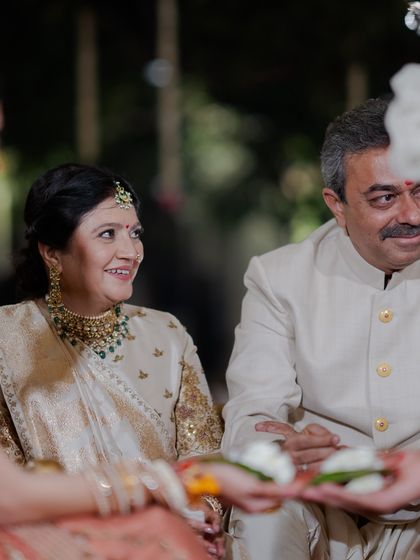 The parents of the groom looking on with love during the ceremony. Their smiles show their happiness, and their elegant attire reflects the importance of the occasion.