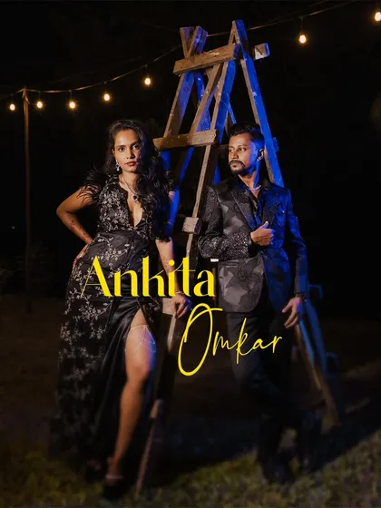 A full-length portrait of the couple at their outdoor cocktail party, with string lights and a rustic ladder creating a cool backdrop.