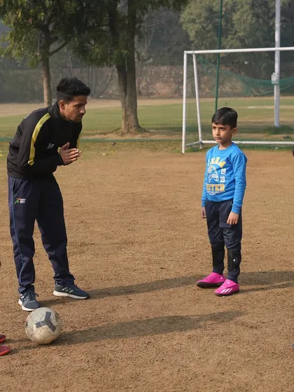 The football field is our classroom. A coach uses a game-like situation to teach three young players about positioning and strategy, turning play into a valuable lesson.