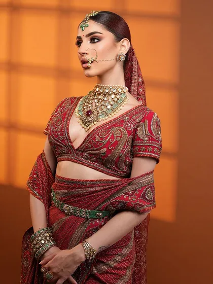 Regal Elegance. A full shot of this beautiful bride in a classic red saree, with makeup that is both bold and timeless.