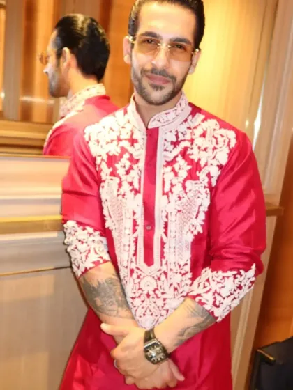 A client in a vibrant red kurta with heavy white thread embroidery around the neckline. This is a powerful and festive choice for celebrations like Diwali or a wedding sangeet.
