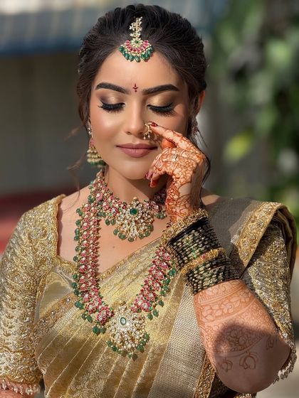 This shot captures the bride's delicate features and the flawless application of her makeup, including the traditional nose ring.