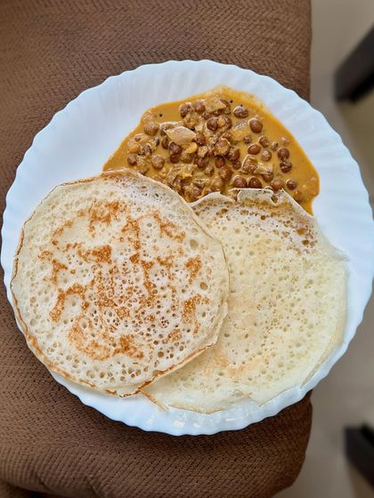A traditional South Indian breakfast of appam served with a flavorful horse gram curry.
