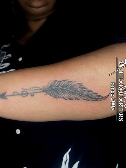 A feather combined with an arrow and musical notes, a creative design that blends symbols of freedom, direction, and music.