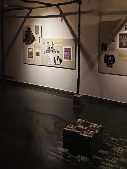 Another view of the installation, showing the raw wooden supports and the box of punch cards.