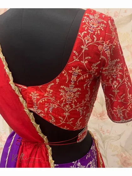 The detailed back of the red embroidered blouse for the half-saree, showcasing the fine craftsmanship and the elegant V-cut back.