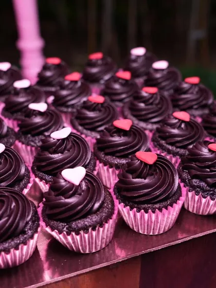 Mini chocolate ganache cupcakes with tiny hearts, created for a pink-themed bachelorette party. These bite-sized desserts are always a crowd-pleaser.