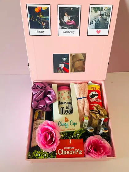 The hamper includes mini liquor bottles, snacks, a travel cup, and other fun items, all beautifully arranged in the pink box.