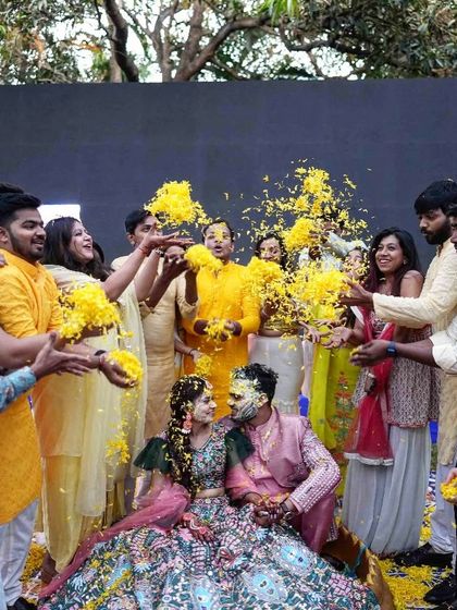 The love and happiness are palpable as friends and family shower the couple with flowers during their Haldi.