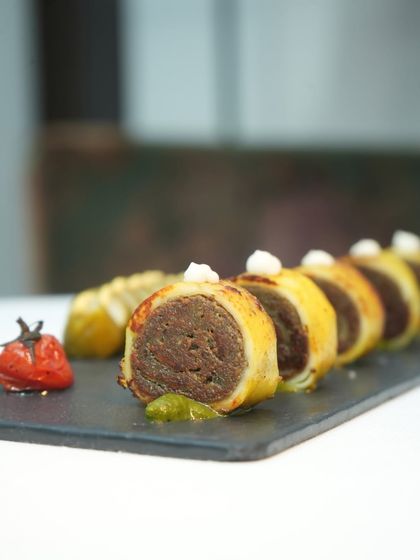 A closer view of our baked paneer rolls, showcasing the intricate layers and the dollop of cream that balances the flavours. It’s a dish that is both classic and new.