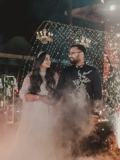 The full effect of the pyrotechnic entrance. The couple is framed by sparklers, creating a high-impact, celebratory moment as they enter their Sangeet.