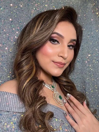 A close-up of the soft waves and smokey eye makeup. The highlights in the hair add dimension and texture to the style.