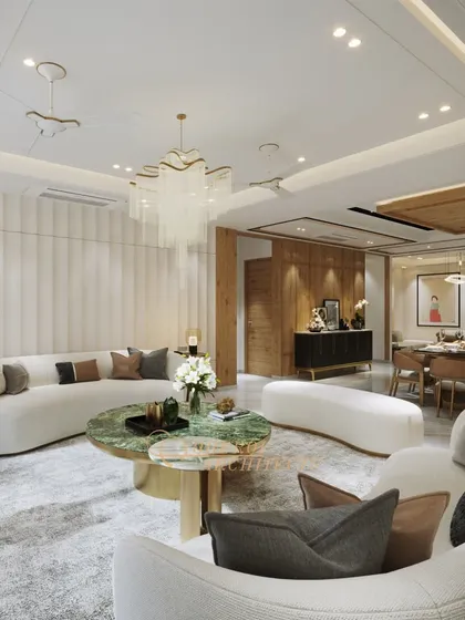 A wide view of a living and dining area where soft, curved sofas and a striking green marble coffee table create a focal point. The design balances modern forms with timeless materials.