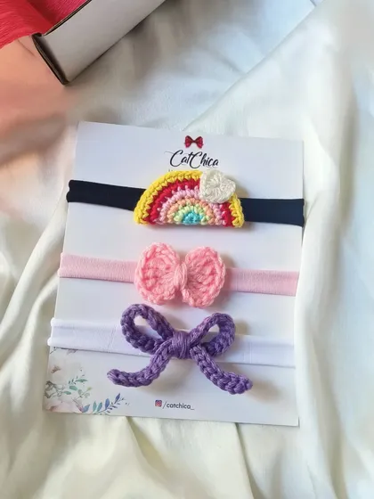 This newborn headband set of three is one of our most popular for gifts. It includes a rainbow, a pink bow, and a purple bow, all on soft, stretchy bands.