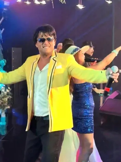 A candid shot from the Bali wedding performance. The yellow jacket and bright lights reflect the vibrant, celebratory mood of the entire evening.